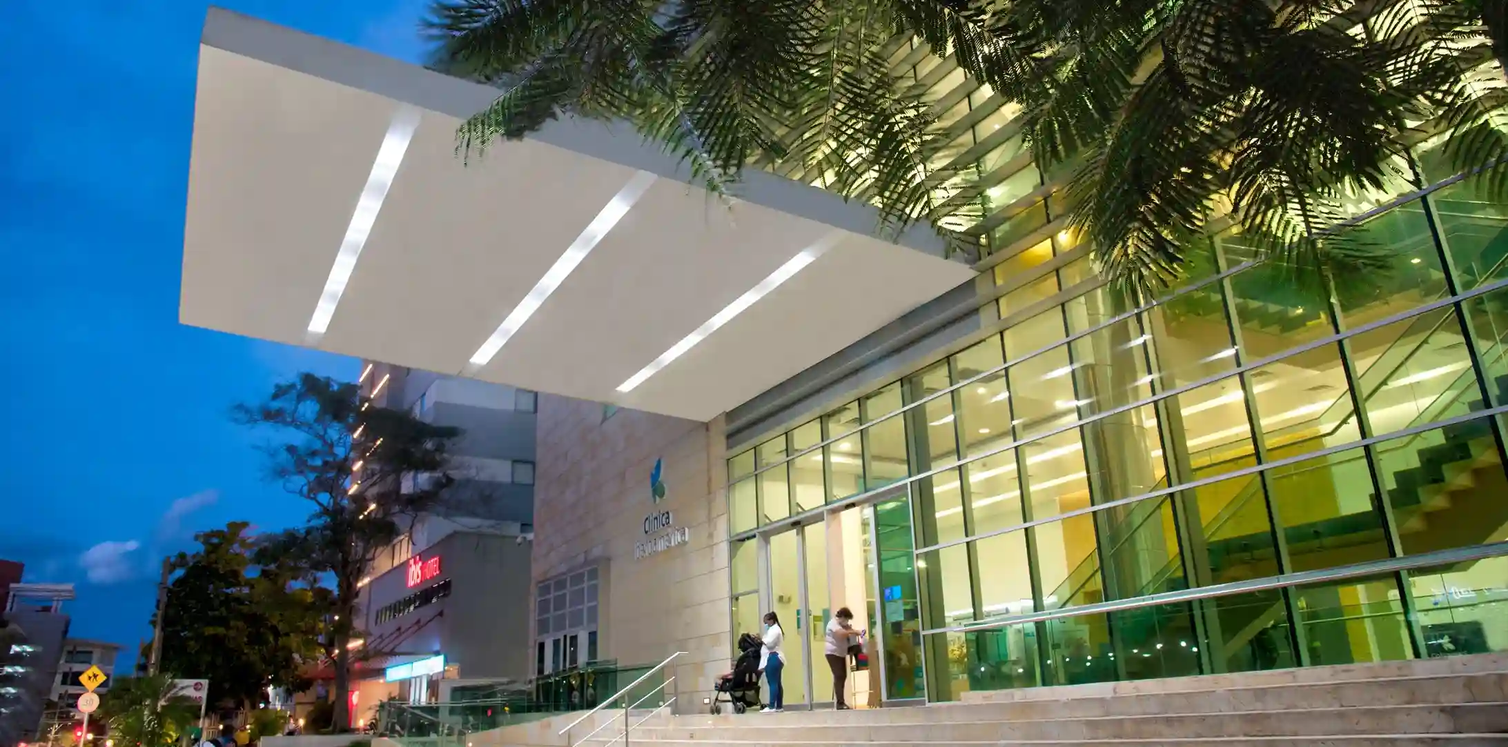 Entrada principal de la Clínica Iberoamérica en Barranquilla iluminada de noche
